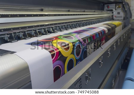 Large format printing machine in operation. Industry Royalty-Free Stock Photo #749745088