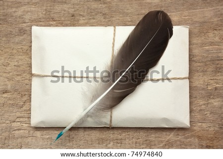 letter and a quill  on a wooden background