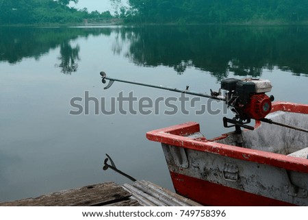 the boat with machine floating near the wood floor front of the raft