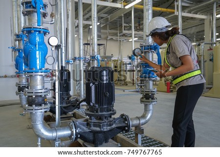 Young woman mechanical engineer inspection heating system on pressure gauge of industrial air compressor pump system at air compressor pump room in the factory Royalty-Free Stock Photo #749767765