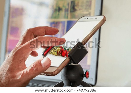 Men hand presses on  touch screen digital of smartphone with  christmas ornament