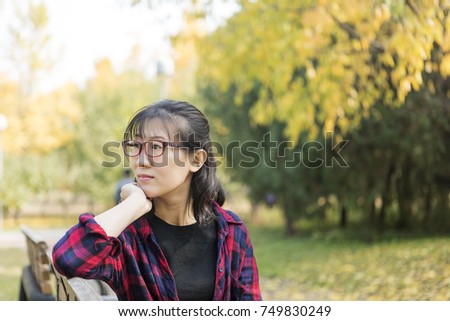 Beautiful asian woman smiling enjoy the sunshine in the park in autumn