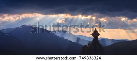 Meditation in a yoga position on the top of mountain above the misty valley. Zen, meditation, peace