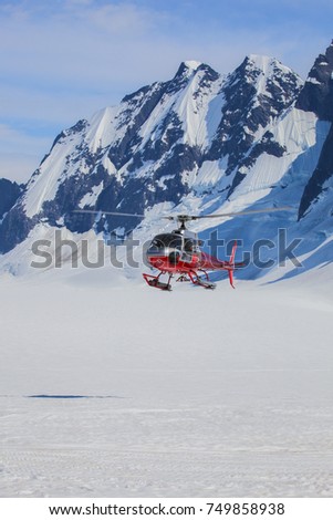 rescue helicopter flying low over a snowy glacier. 
