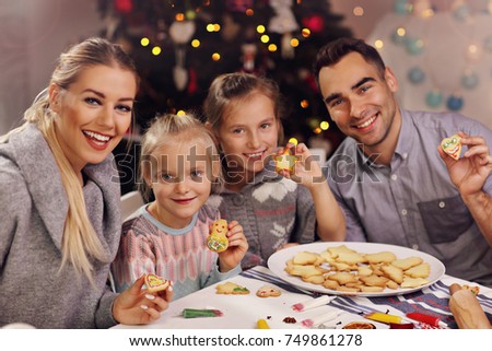 Picture showing joyful family preparing Christmas biscuits