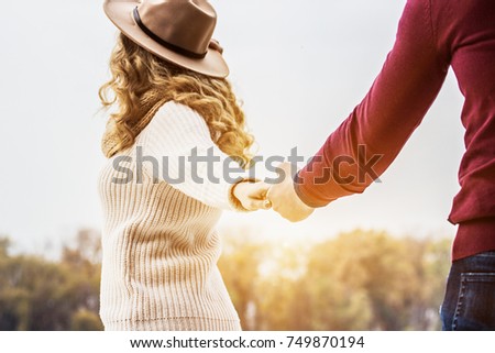 Honey, follow me. Back view of beautiful blonde woman holding her boyfriend hand and walking away outdoors. Romantic love story. Couple in love. Togetherness concept. Couple holding hands. Royalty-Free Stock Photo #749870194