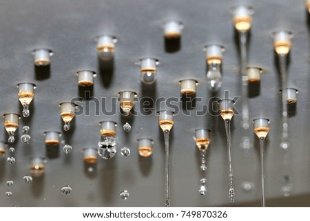 flowing jets and drops of clean water from the shower head nozzles 