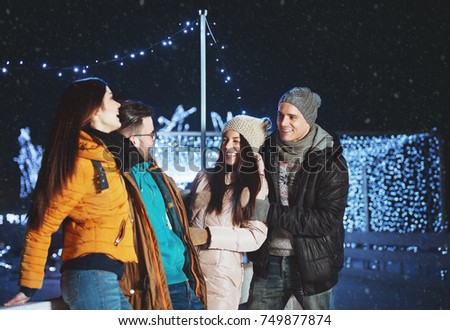Young people outdoors having fun on a winter evening 