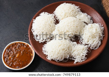 Noolappam Idiyappam / rice noodles,  popular traditional steam cooked Kerala breakfast dish with hot spicy black bengal gram or Kadala curry  Alleppey, India. South Indian food.