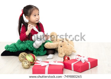Asian little girl wearing red shirt Wearing a green skirt Hold a gift box
And Christmas Decorations
