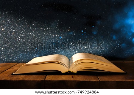 image of open antique book on wooden table with glitter overlay Royalty-Free Stock Photo #749924884