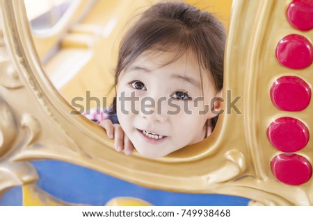 Happy cute asian girl playing in the playground.