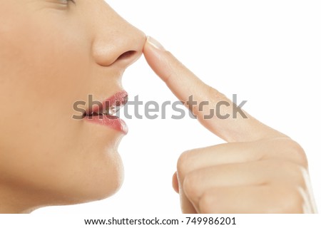 Young woman touching her nose with her finger Royalty-Free Stock Photo #749986201