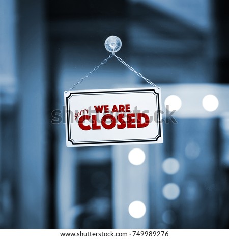 WE ARE CLOSED sign board through the glass of store window. Filtered image. Royalty-Free Stock Photo #749989276