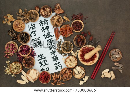 Chinese herbs used in alternative herbal medicine with calligraphy script on rice paper. Translation reads as traditional ancient chinese medicine to heal mind, body and spirit.