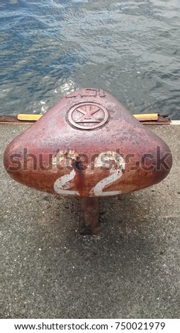 Japanese numbered mooring in Osaka harbor with sea pictured.