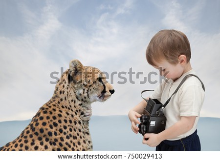 Little boy with old camera photographs big cat