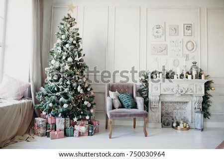 warm cozy beautiful modern design of the room in delicate light colors decorated with Christmas tree and decorative elements fireplace 
