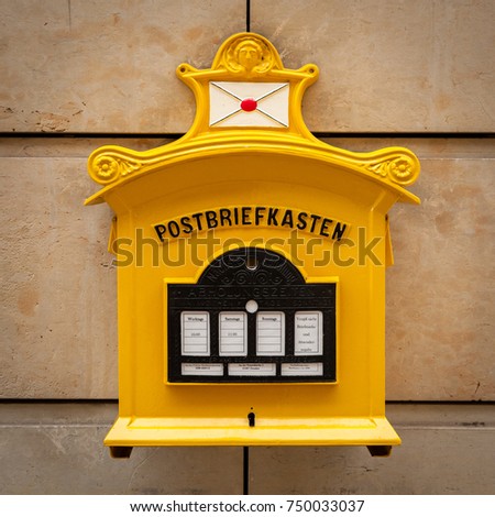 An old vintage yellow mailbox in Dresden Germany with inscription "Mailbox"
