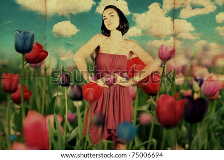 beauty young woman in red dress on the meadow with flowers tulips