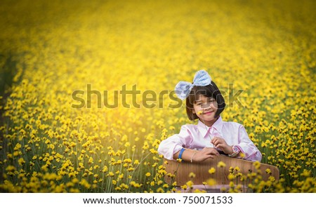 Pink girl In a field of yellow flowers.