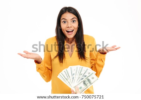 Portrait of a satisfied happy woman receiving bunch of money banknotes and looking at camera isolated over white background