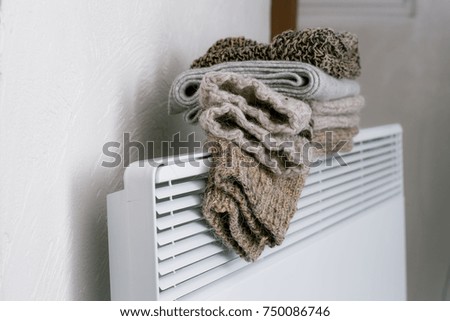 Socks made of wool lie on warm heating. The heating and warm clothes.
