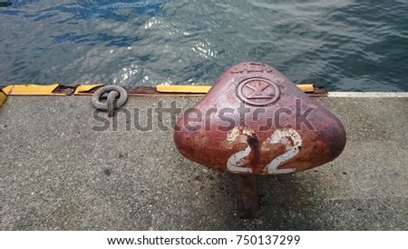 Landscape of red numbered mooring in Osaka Japan with sea pictured taken on a cloudy autumn afternoon.
