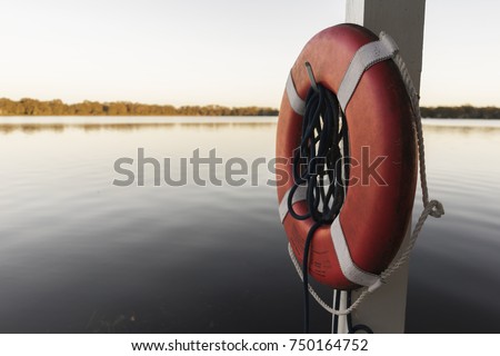 Life Perserver On A Boat Dock Near The Water Royalty-Free Stock Photo #750164752