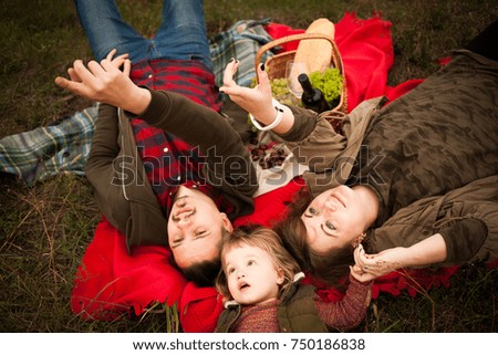 Happy family with a young child on a picnic in autumn.