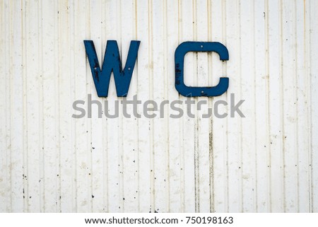 White metal wall with WC sign