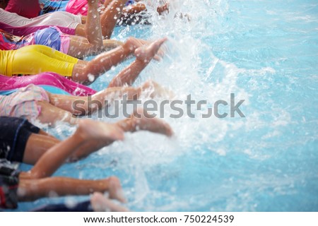 group of children at swimming pool class learning to swim