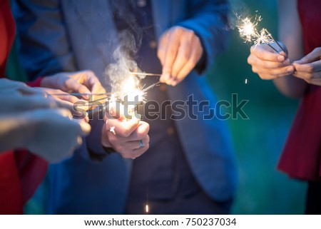 Blurry of hands with firework.Picture showing group of friends having fun with sparklers