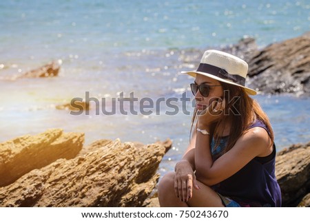 Beautiful fashionable woman in a hat and sunglasses posing.