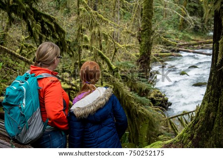 Mother and Daughter Hiking Alsea Falls: A mother and daughter hike along the South Fork Alsea River near the Alsea Falls. Royalty-Free Stock Photo #750252175