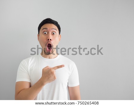 Shocked face of Asian man in white shirt on grey background. Royalty-Free Stock Photo #750265408