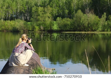 Happy young girl with camera outdoors 