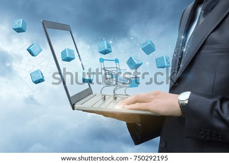 Shopping cart on laptop businessman with and fly interest. The concept of discounts in online store.