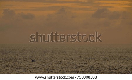 Only one boat in a gigantic sea. A bit clouds in the sunset sky. Scenic View of Andaman Sea, Phuket, Thailand.