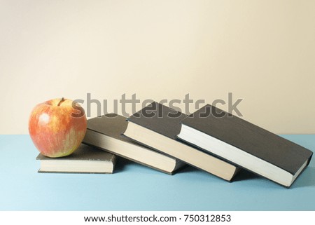 Stack of books and apple on the table. Copy space for text. Back to school. Education concept.