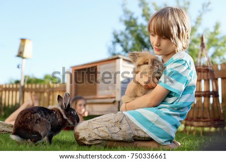 Boy playing with rabbit in garden