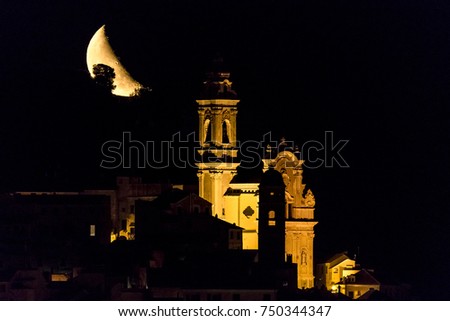Night view of Cervo Cathedral and its churches with moon rising in background, Liguria, Italy. A black night over mediterranean sea. Il paese di Cervo di notte al sorgere della Luna.