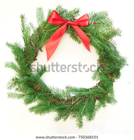 Christmas fresh natural wreath from spruce branch with red bow on white background. Square image. Isolated.