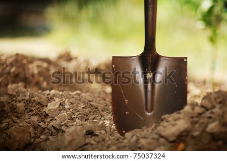 Soil with shovel. Close-up, shallow DOF. Royalty-Free Stock Photo #75037324