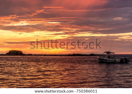 Beautiful Orange Sky Sunset into the Pacific Ocean with Islands and Boats Moored  in the Foreground