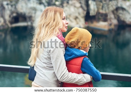 Mom and son enjoying beautiful lake view. 