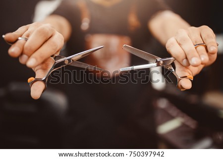 Barbershop Close-up of barber holds clip-on hair clipper Royalty-Free Stock Photo #750397942