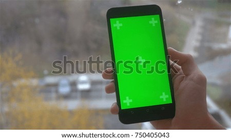 a young man and a green screen smartphone.