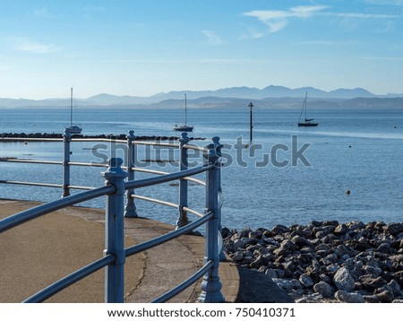 Boats in Morecambe Bay viewed from promenade with Lake District Hills in background