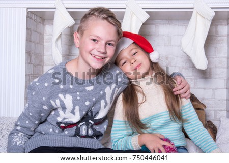 Portrait of little boy and girl in christmas hat. Christmas family holiday concept. Merry Christmas and Happy Holidays. New Year's picture of brother and sister. 